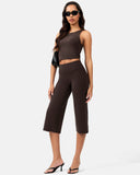 Woman wearing a brown crop top and high-waisted cropped activewear pants with black sunglasses.