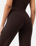 Rear view of a woman wearing high-waisted, dark brown workout leggings.