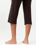 Lower body view of a woman wearing dark brown cropped yoga pants.