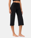 Woman wearing black high-waisted cropped yoga pants in a wide-leg fit.