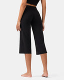 Rear view of a woman wearing black high-waisted wide-leg yoga pants.