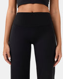 Woman wearing high-waisted black activewear leggings and a matching crop top.