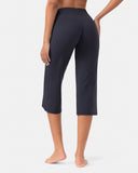 Rear view of a woman wearing high-waisted black cropped yoga pants.
