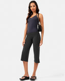 Woman wearing a charcoal grey V-neck activewear top and matching cropped yoga pants.
