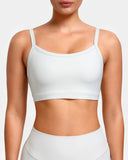 Woman wearing a white seamless sports bra and matching high-waisted activewear bottoms.