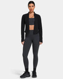 Woman wearing a black zip-up jacket, grey sports bra, and high-waisted grey leggings.